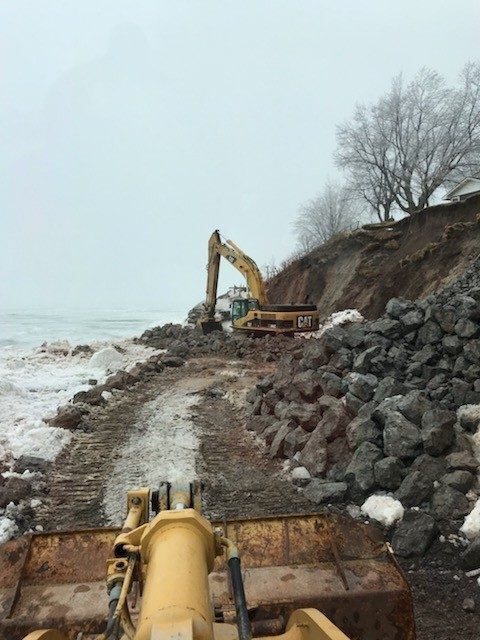 Excavator working at the base of an eroding Lake Erie bank